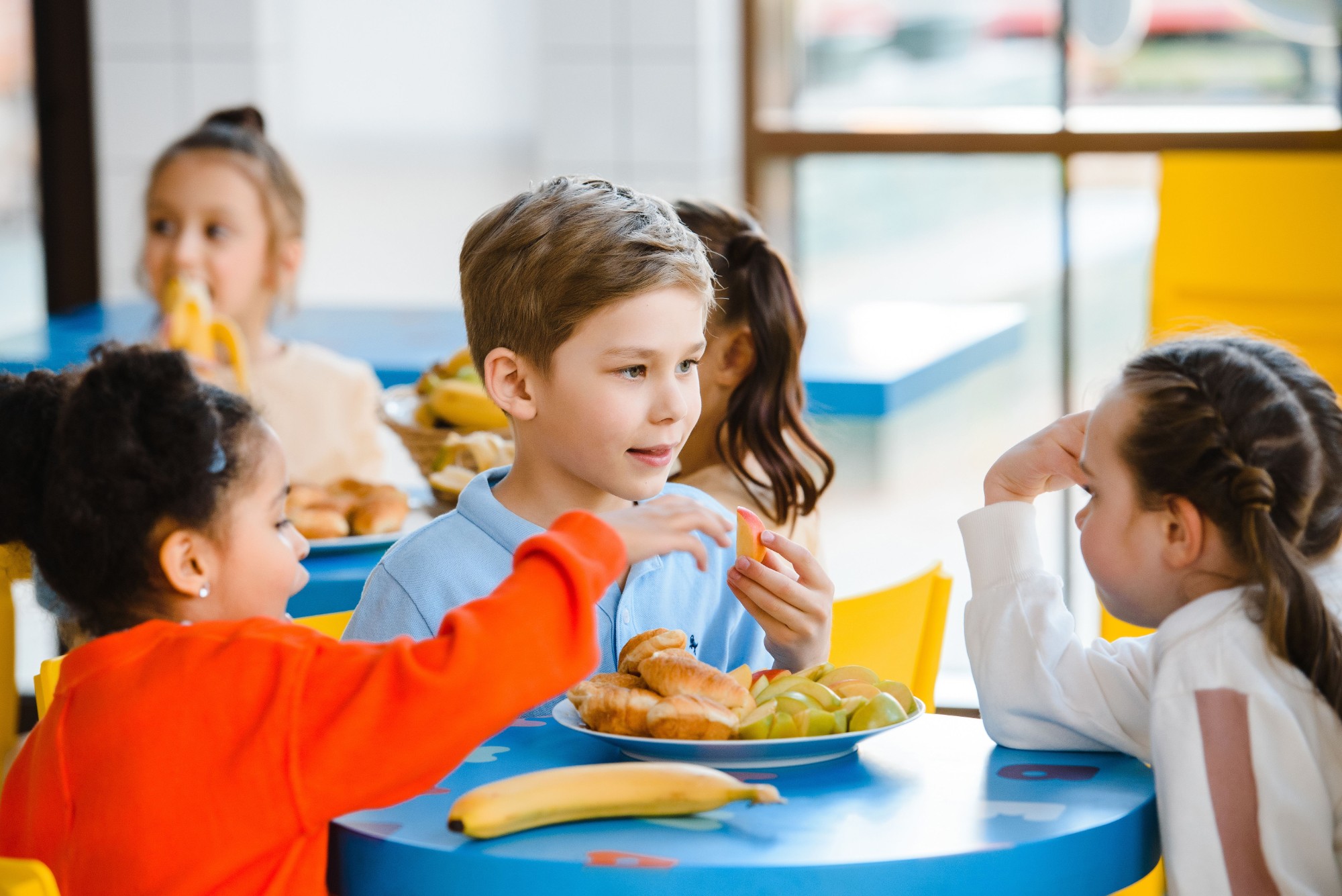 Primary school children eating breakfast at a school breakfast club