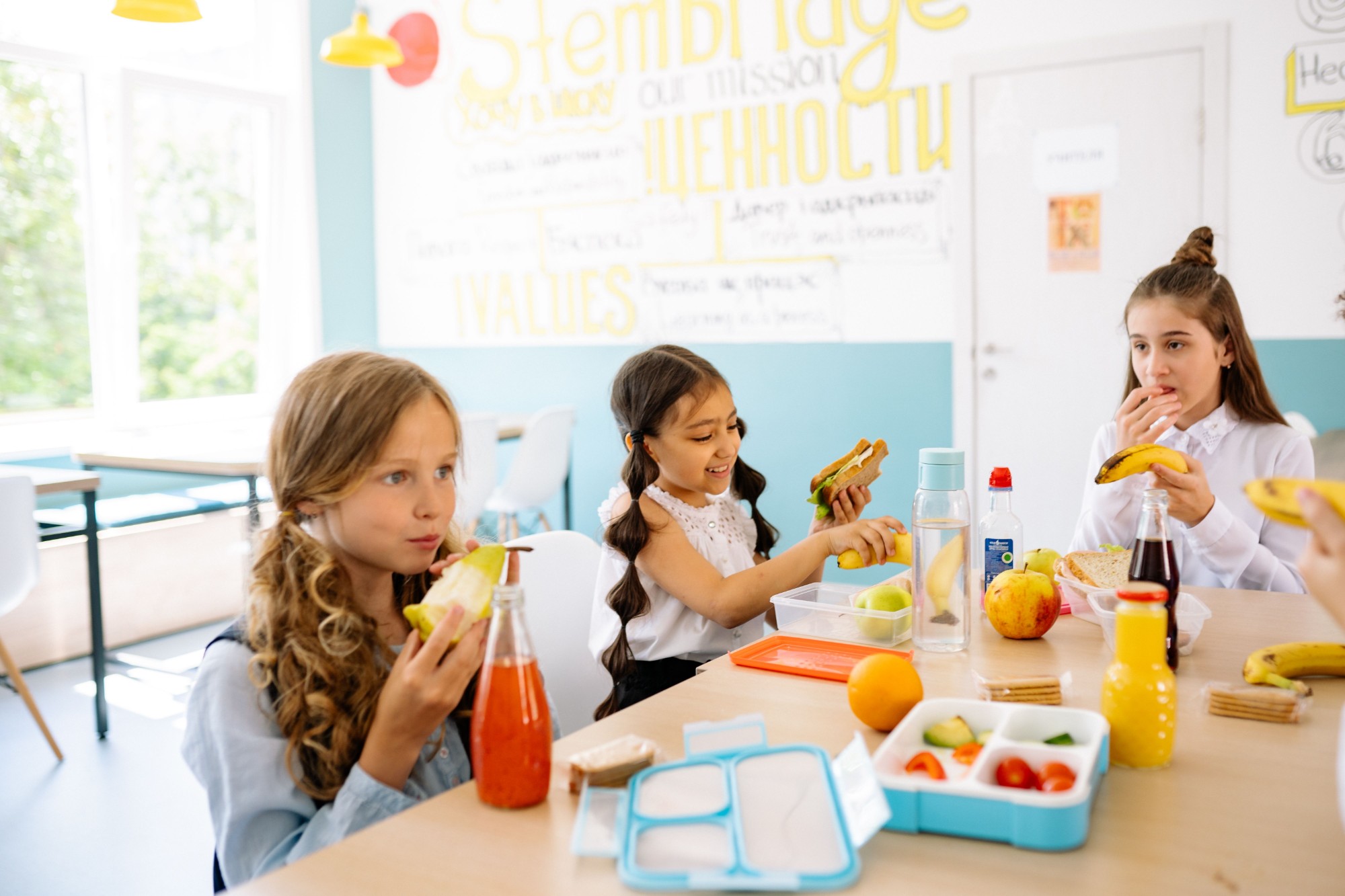 Young children eating at a free breakfast club in a primary school