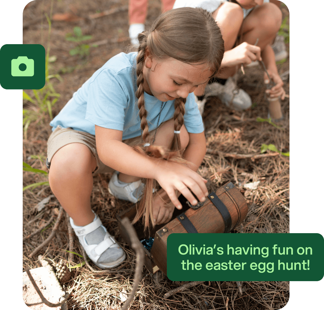 A child in a blue t-shirt plays with a treasure chest with a smile, reflecting. Text reads 'Olivia's having fun on the easter egg hunt' reflecting a message sent to the parent of the child which lets schools and clubs stay connected and engaged.